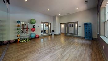 A large fitness room with hardwood floors and a large window